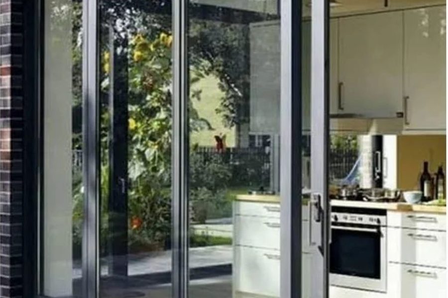 Wide aluminium sliding door between a kitchen and a dining area