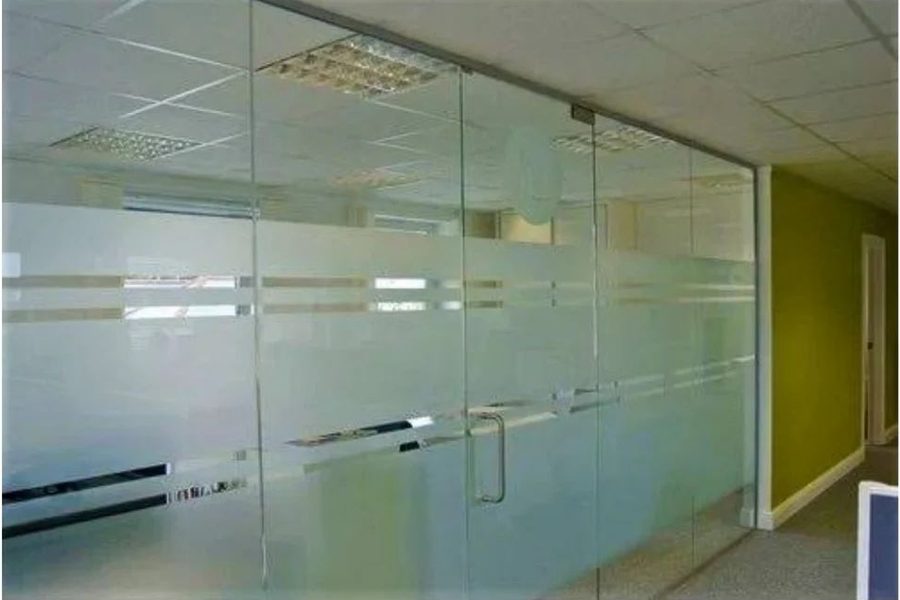 Glass partition wall with a frameless glass door